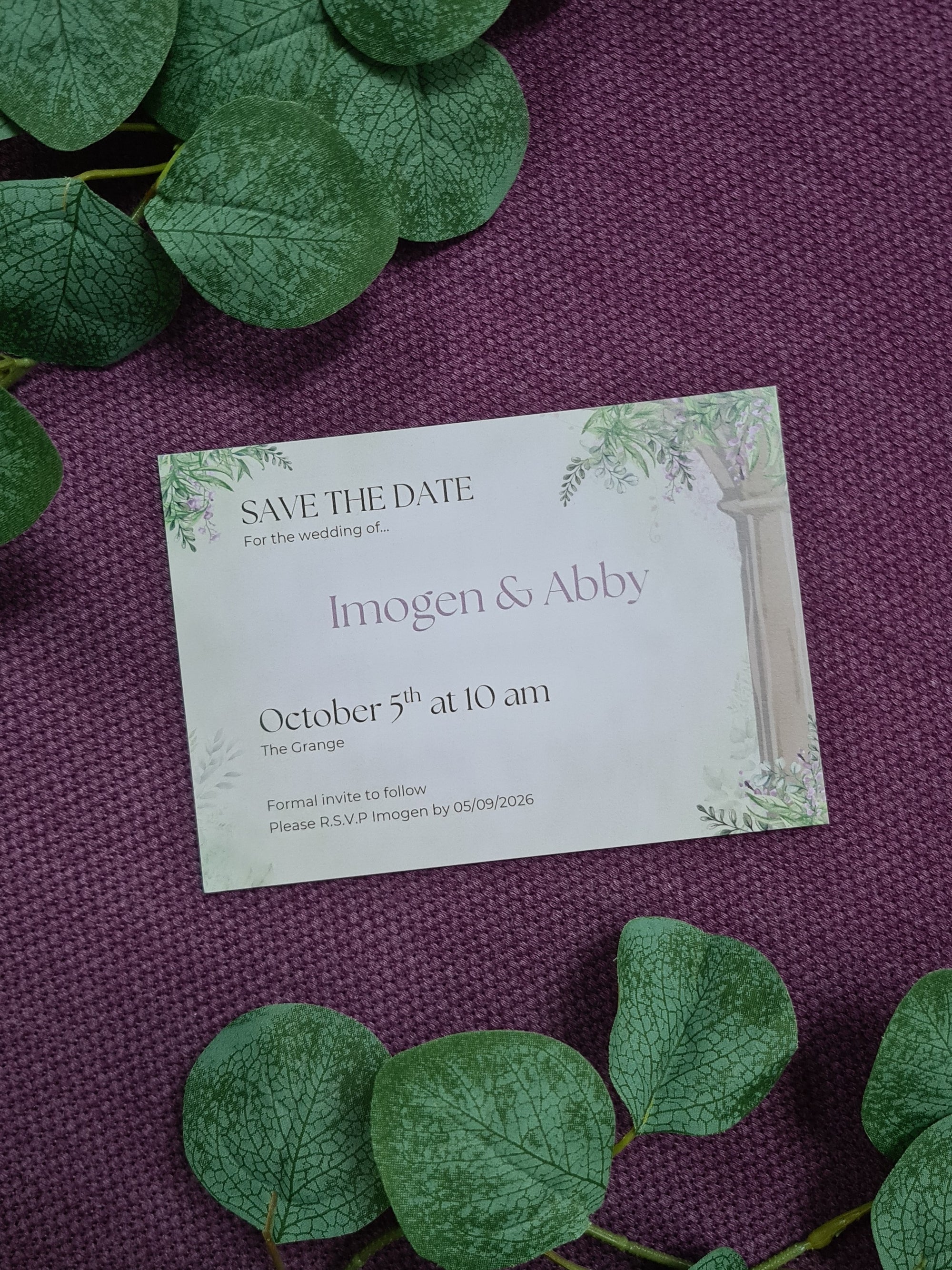 ALÈCLEE Designs - Wisteria Fairy-Tale Wedding Stationary - Save-the-Date. Fairy-tale inspired wedding invitation featuring cascading wisteria, lush greenery, and elegant stone pillars, capturing a timeless romantic setting.