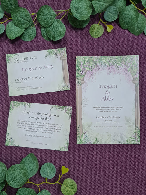 ALÈCLEE Designs - Wisteria Fairy-Tale Wedding Stationary Collection. Fairy-tale inspired wedding invitation featuring cascading wisteria, lush greenery, and elegant stone pillars, capturing a timeless romantic setting.